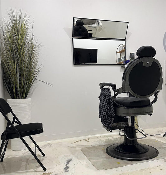 Barber chair in a salon setting with Linear Dimension Mirror and plant.
