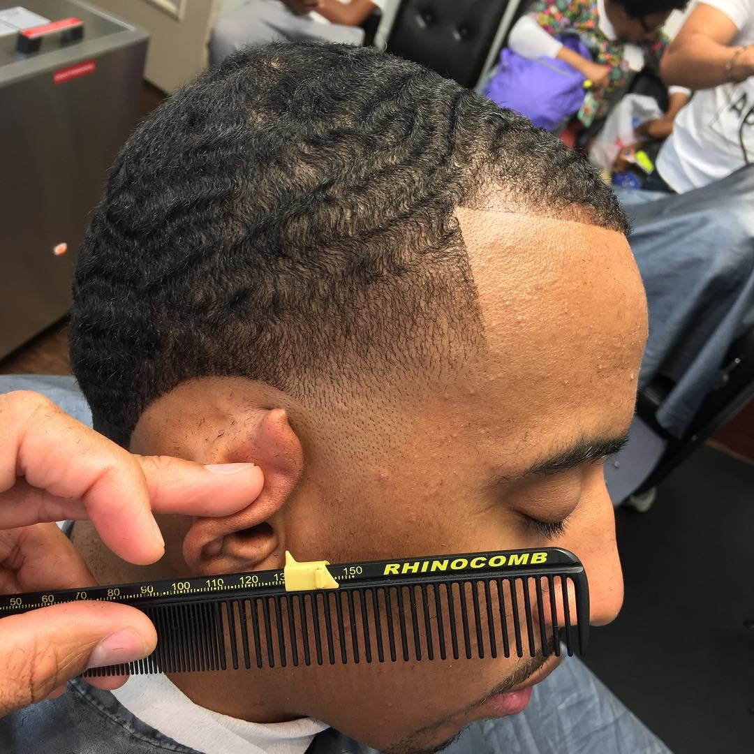 Person getting a haircut with a Rhinocomb, surrounded by salon equipment and people.